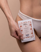 Person in white underwear holding Pinc Wellness packet on thigh, clean vibe.