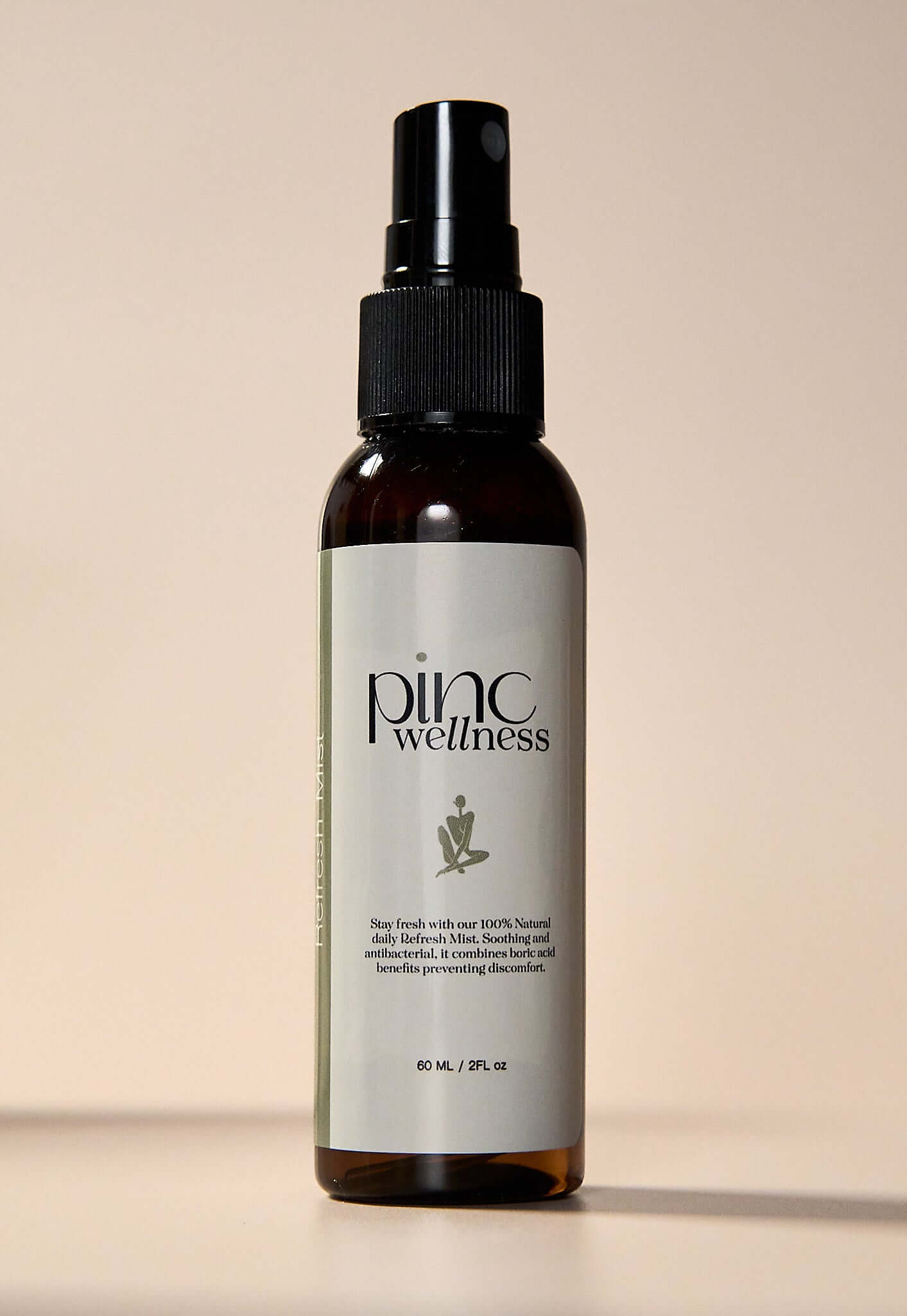 Brown "Pinc Wellness" spray bottle on beige, natural daily refresh mist.
