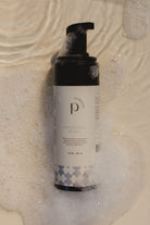 Bottle of Pinc Wellness Intimate Wash for Men lying in water and bubbles