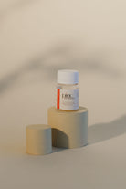 Bottle of Pinc Wellness Natural Lubricant Capsules sitting on a round platform