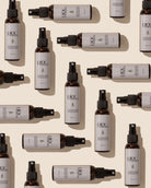 Dark amber spray bottles with white labels on light beige, arranged neatly.