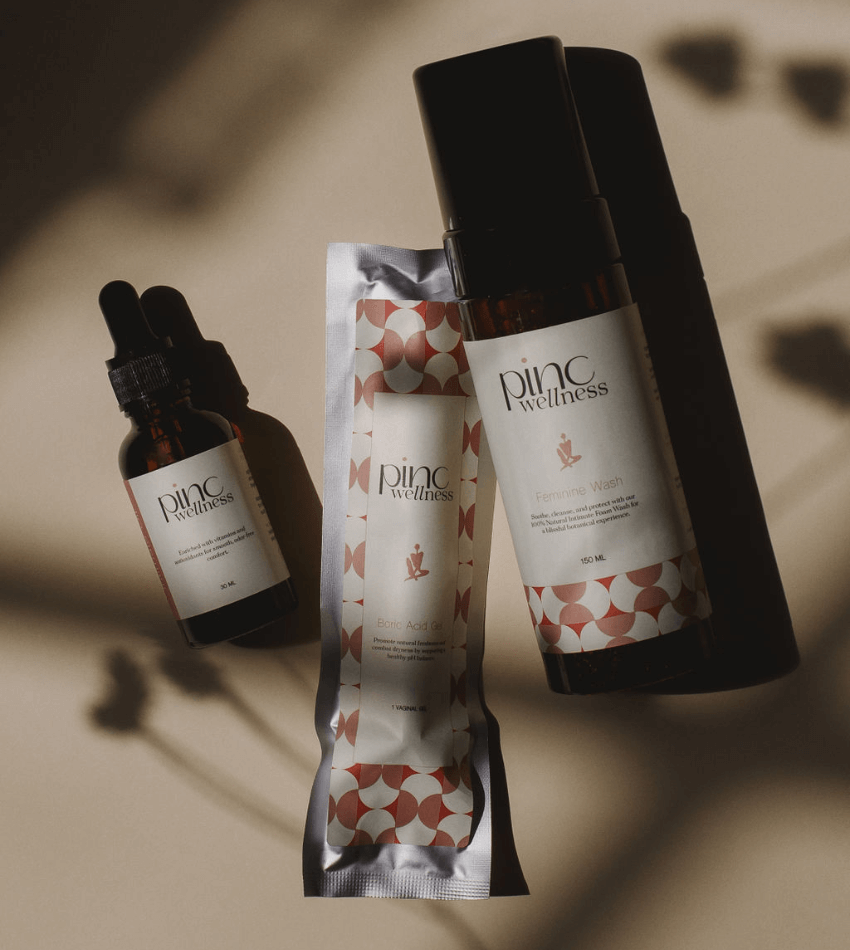 Three Pinc Wellness skincare products on beige, soft shadows, natural feel.