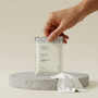 Hand holding a package labeled 'pine wellness' on a neutral background